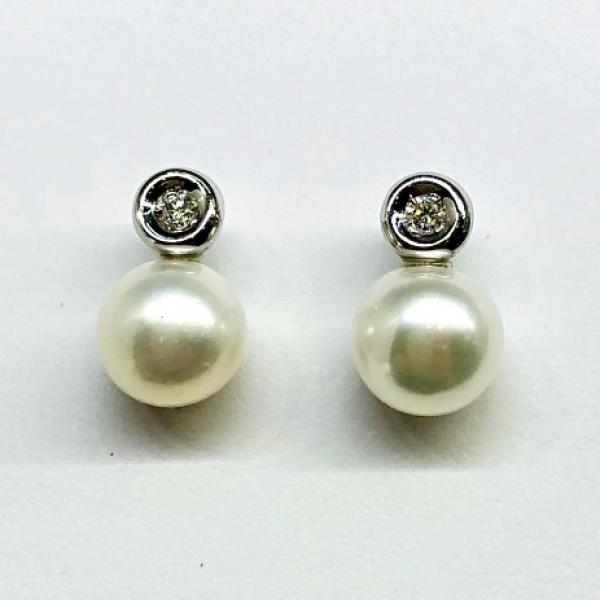 14 karátos fehér arany brill fülbevaló. Tisztasága és színe a nemzetközi besorolás szerint: vs,g, nagysága 0,04ct, édesvízi tenyésztett gyönggyel díszítve.