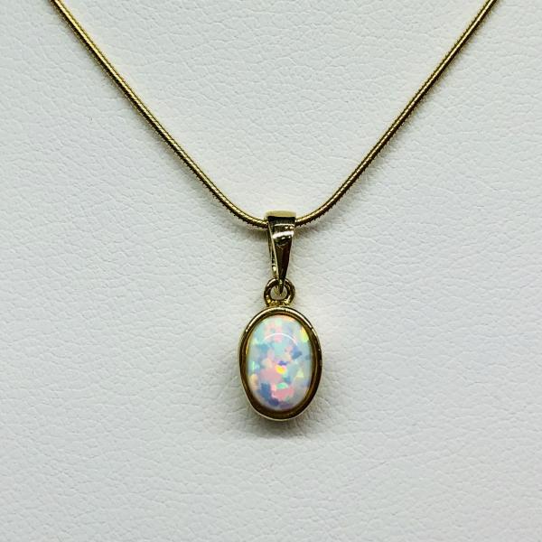 14 karátos sárga arany medál szintetikus opállal. A medál súlya 0,8gr.